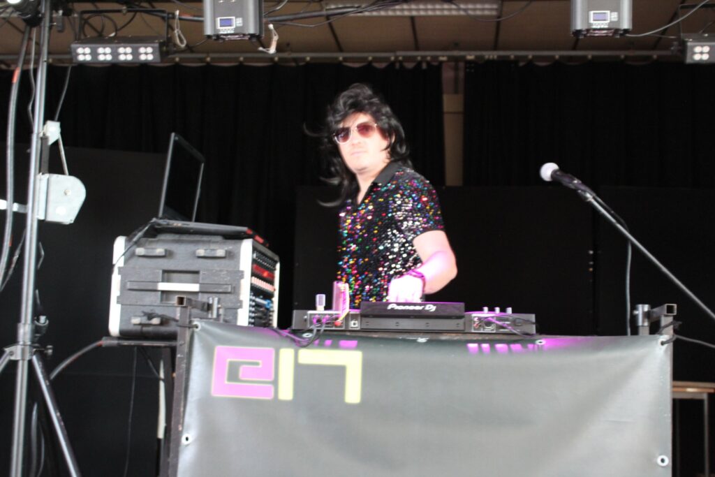 Le DJ event17 aux platines en tenue de soirée à paillettes